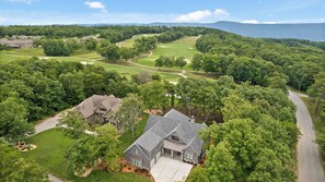 A residential area with houses, a golf course, and a road. - McLemore Resort - 18 Hawthorne Lane - Golf Course View (Rising Fawn)