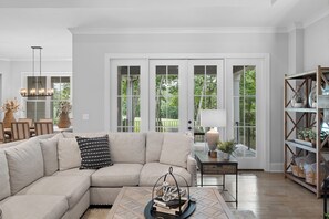 A modern living room with a sectional sofa, a coffee table, and a bookshelf. - McLemore Resort - 18 Hawthorne Lane - Golf Course View (Rising Fawn)