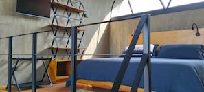 Een slaapkamer met een stapelbed, een ladder, een aan de muur bevestigde televisie en een raam.