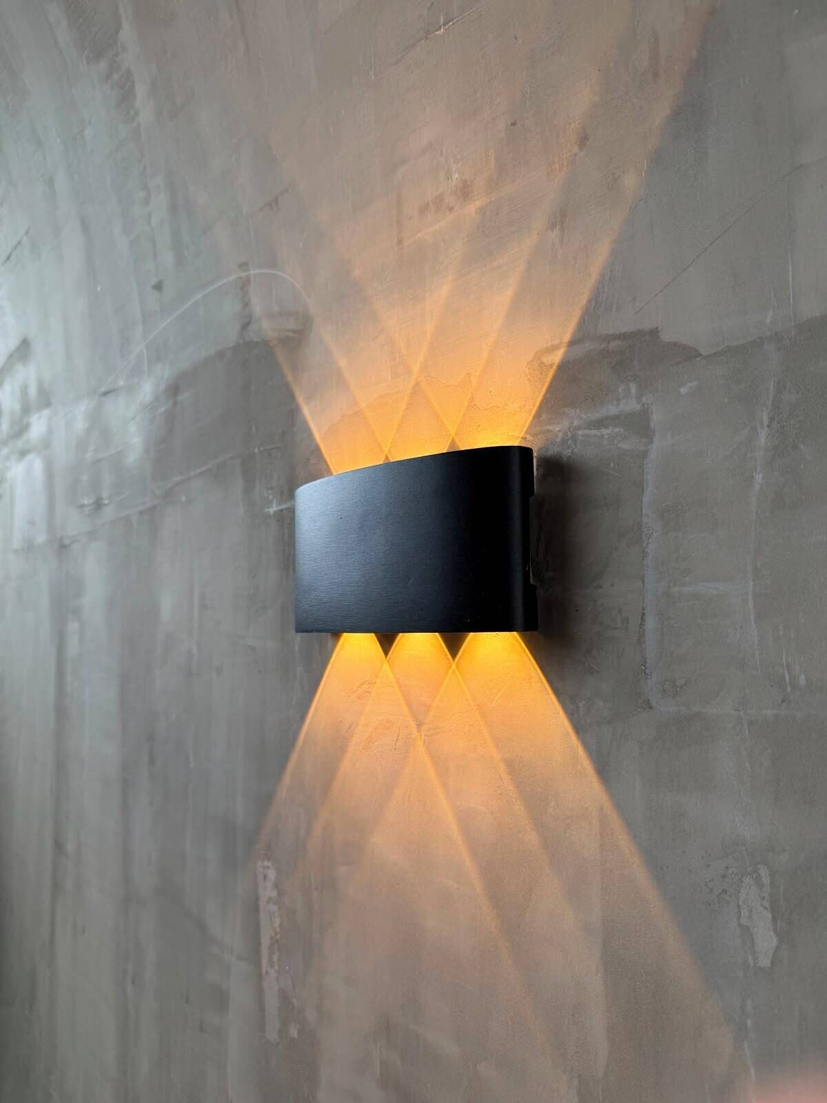 Een wandlamp met een rechthoekige vorm en zwarte afwerking.