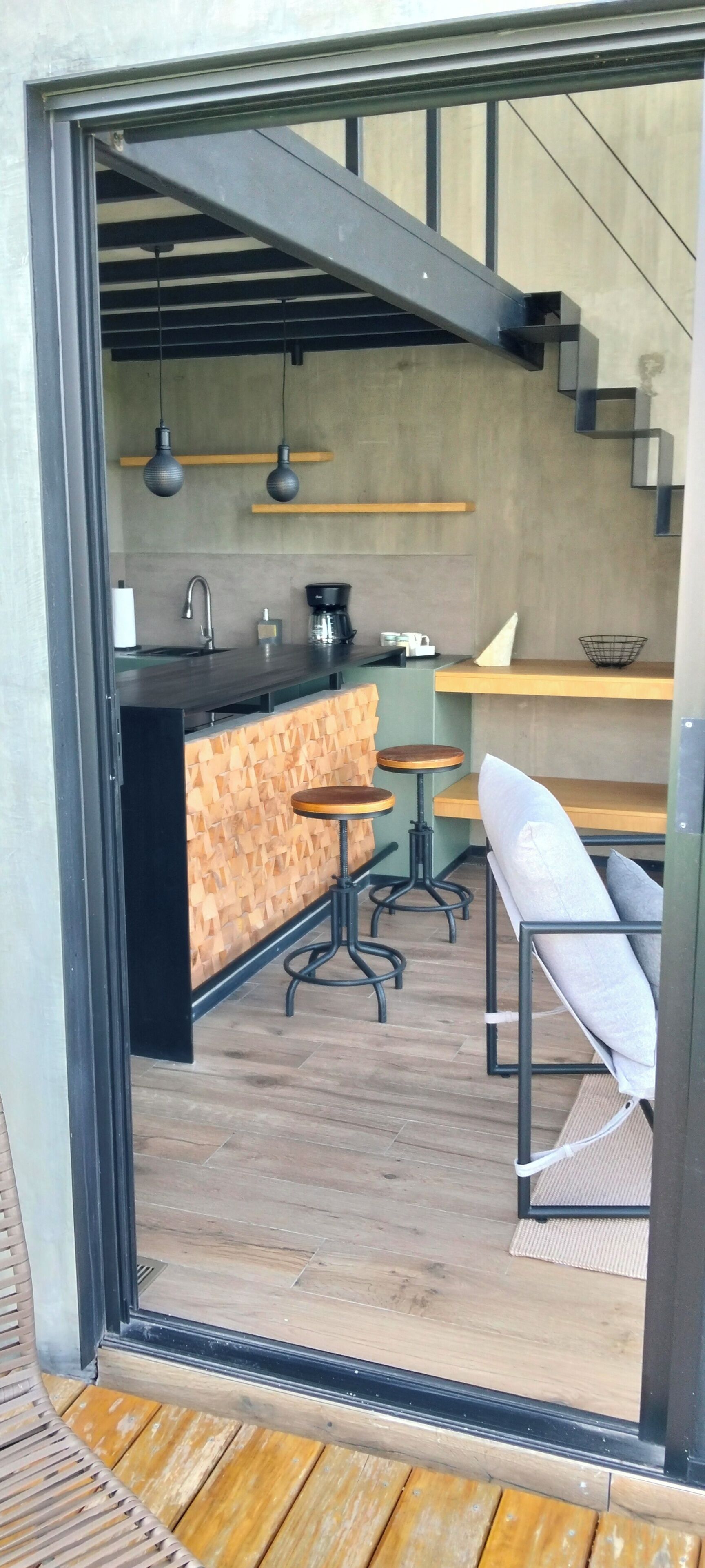 Ein modernes Interieur mit Küchenbereich, Holzböden und einer Treppe.