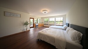 Una camera da letto con due letti, un angolo cottura e vista sull'esterno.