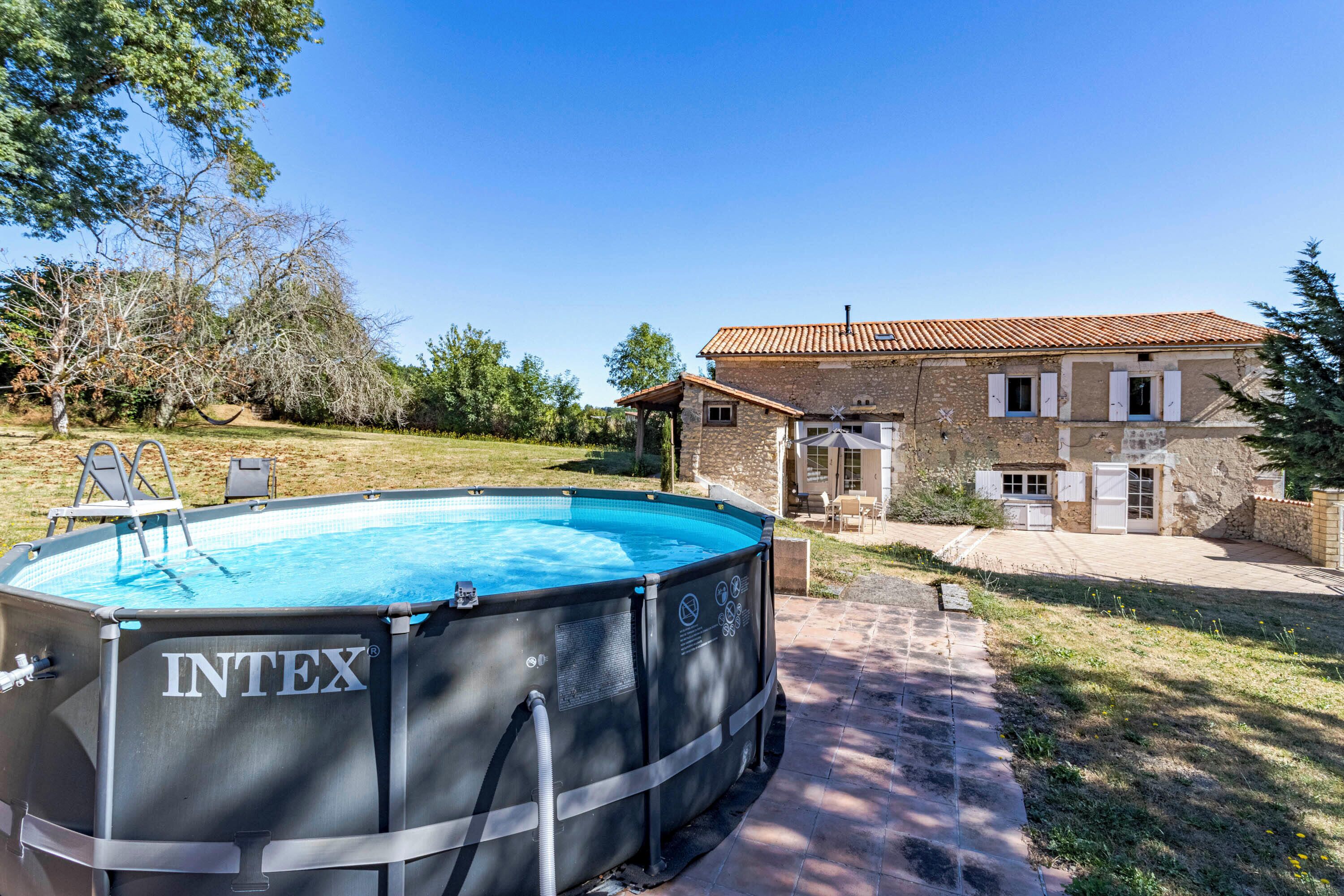 A swimming pool, a house, and a clear sky.