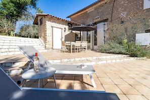 A stone building with a patio, outdoor seating, and a bottle of wine. - La Courberie - Piscine - Petfriendly (Villetoureix)