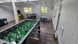 Una habitación con una mesa de fútbol de mesa, una ventana y una puerta.