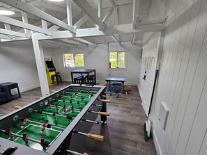 Ein Zimmer mit einem Kicker, einem Fenster und einer Tür.
