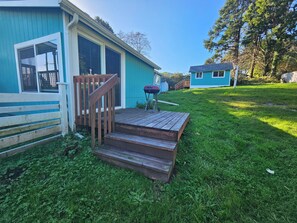 Ein Haus mit einer Holzterrasse und einer Treppe zum Eingang.