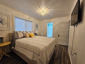 A bedroom with a bed, bedside table, lamp, and a ceiling light fixture. - 4 blocks to beach. Dog Friendly. Fenced Yard. In Pacific Beach. Arcade! (Pacific Beach)