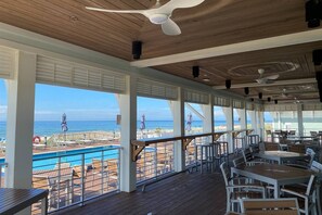 An outdoor deck with tables and chairs, overlooking a pool and beach. - New Listing! Lost Key Golf & Beach Club| 3 king beds| Free Golf Daily| Two Pools| Tennis| Pickleball (Pensacola)