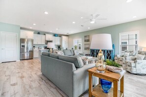 A modern living room with a grey sofa, a wooden coffee table, and a kitchen in the background. - New Listing! Lost Key Golf & Beach Club| 3 king beds| Free Golf Daily| Two Pools| Tennis| Pickleball (Pensacola)