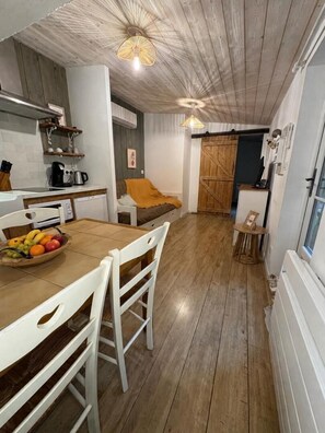A compact kitchen with a wooden ceiling, a dining table with chairs, and a fruit bowl. - Le Logis du Coteau - SAINT-MARTIN-LA-PALLU (SAINT-MARTIN-LA-PALLU)