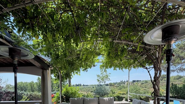 An outdoor seating area with a pergola, sofas, and a table, surrounded by greenery and a view of the landscape. - Family villa with a pool, 2.5 km from the center of Aix-en-Provence ⭐⭐⭐⭐⭐ (Aix-en-Provence)
