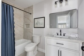 Ein modernes Badezimmer mit Badewanne, Toilette und Waschtisch.
