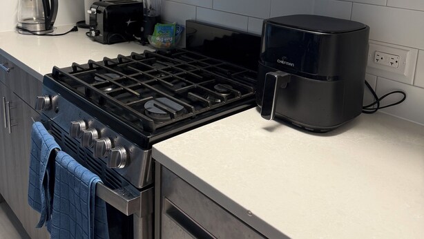 Una cucina moderna con fornello a gas, macchina del caffè e tostapane.