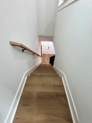 A wooden staircase with white walls and a white door at the top. - Delightful family friendly 3-bedroom house  in Houston (Houston)