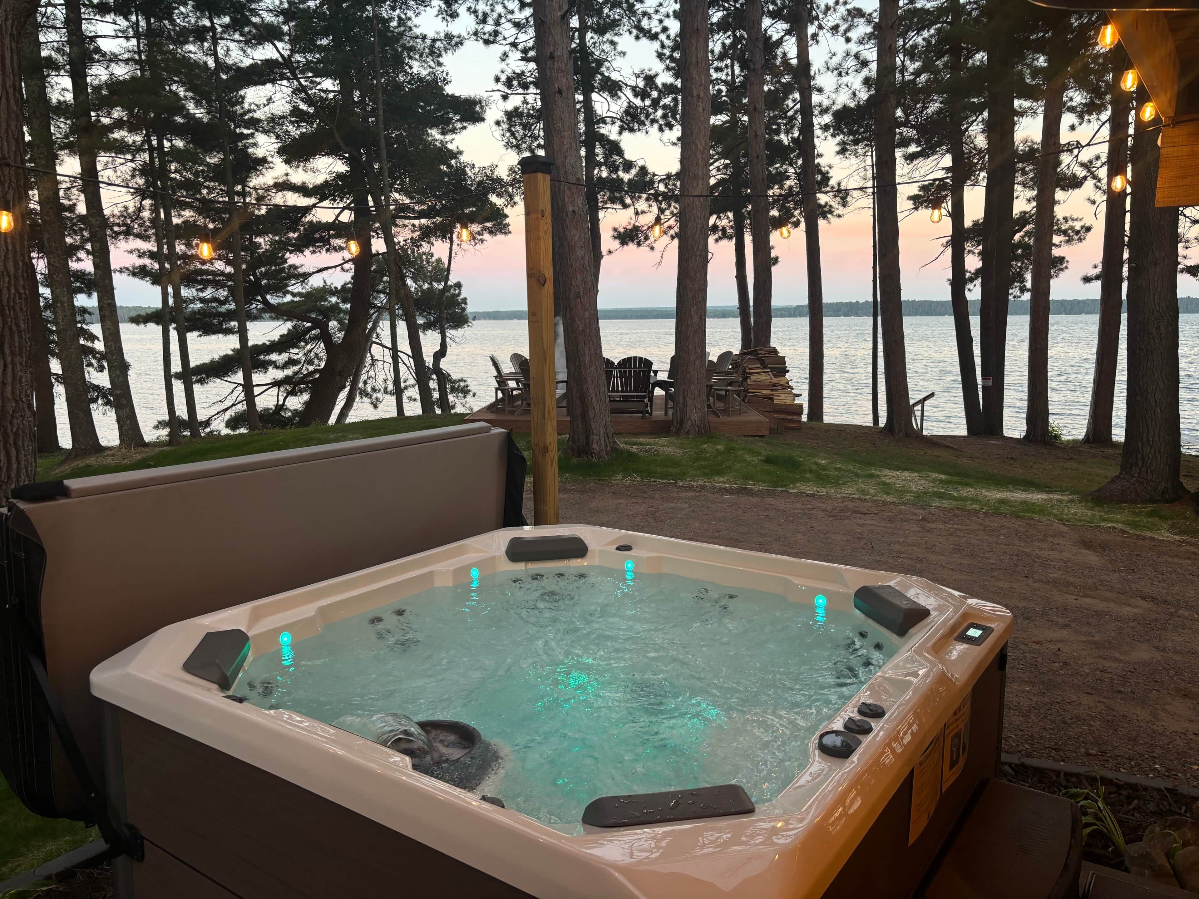 A hot tub with a view of a lake and trees.