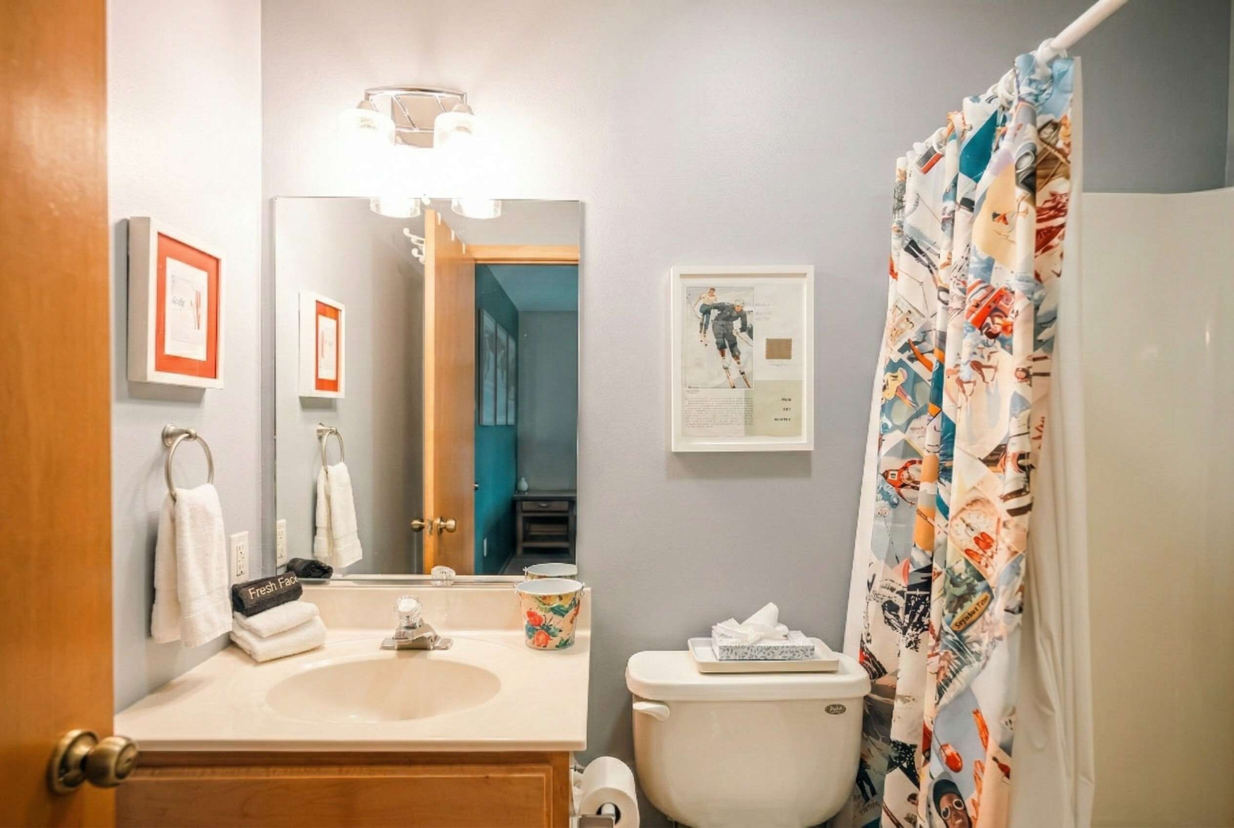 Une salle de bain avec un lavabo, des toilettes et un rideau de douche.