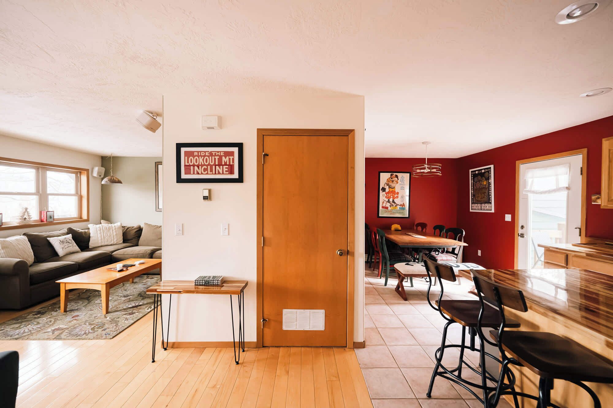 A living room with a sofa, coffee table, and a dining area with chairs and a table.