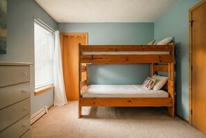 A bunk bed in a room with a dresser, a window with blinds, and a door. - Hot Tub with MTN Views | Bunk Room | Silverthorne (Silverthorne)