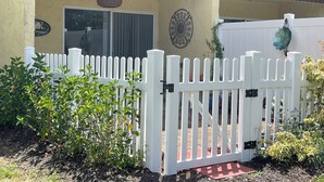 A building with a white picket fence, a door, and a decorative wall. - Sunny Sarasota Escape/ Minutes away from Siesta Key & Downtown (Sarasota)