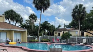 A pool area with lounge chairs, a table, and a fenced swimming pool. - Sunny Sarasota Escape/ Minutes away from Siesta Key & Downtown (Sarasota)