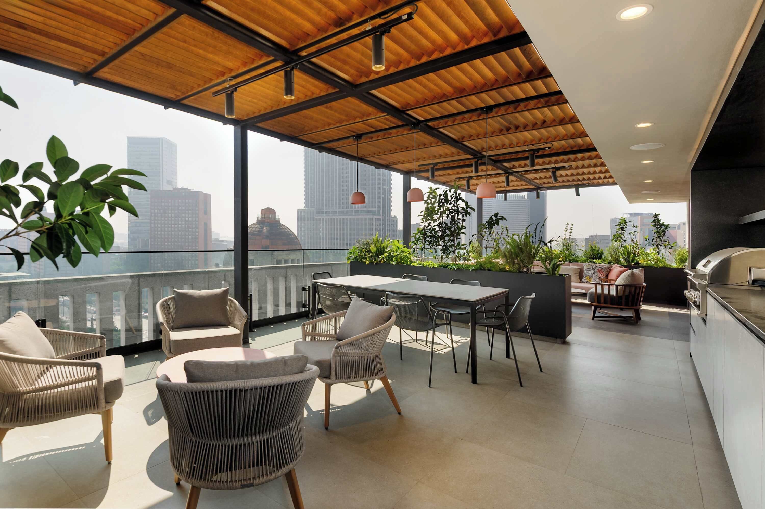 Una terrazza sul tetto con mobili in vimini, un tavolo da pranzo e una zona cucina.
