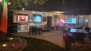An outdoor seating area with tables and chairs, a flag, and a sign for Busch beer. - Bellerive Country Club 3.2 mi to BMW Tourney Golf with Outdoor Bar Chesterfield (Chesterfield)
