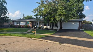 A residential house with a garage, driveway, and a well-maintained lawn. - Bellerive Country Club 3.2 mi to BMW Tourney Golf with Outdoor Bar Chesterfield (Chesterfield)