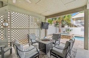 An outdoor patio with a pool, covered seating, and a TV mounted on the wall. - A place to Wine Down in Cherry Grove! Pool, Hot Tub & Optional Golf Cart (Atlantic Beach)