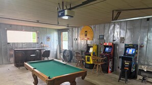 A pool table, arcade machines, and a bar area in a room with metal walls and a wooden ceiling. - O-TOWN OASIS!  Near Oneida Baptist Institute & 10 miles from Manchester, KY (Oneida)