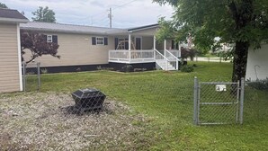 A residential property with a fenced yard, a covered porch, and a small outdoor grill. - O-TOWN OASIS!  Near Oneida Baptist Institute & 10 miles from Manchester, KY (Oneida)