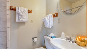Un bagno con il water, un lavandino e un porta asciugamani.