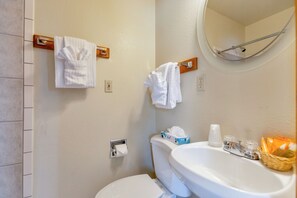 Ein Badezimmer mit Toilette, Waschbecken und Handtuchhalter.