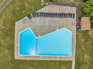 An aerial view of a swimming pool with a surrounding deck and lounge chairs. - Lake House Mansion | Dock+Kayaks+FirePit+Swim Spa (Long Pond)