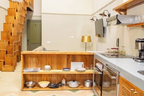 Una cocina con estantes de madera, un lavamanos, una estufa y un microondas.