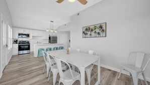 Een moderne keuken met witte kastjes, roestvrijstalen apparatuur en een centraal eiland.