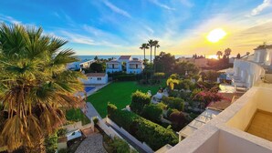 A residential area with white buildings, a green lawn, and a clear sky. - Beach villa with ocean view and rooftop cinema (Guia)
