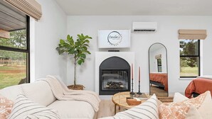 Una sala de estar moderna con chimenea, un espejo grande y vistas al exterior.