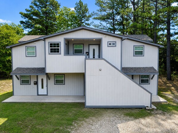 A two-story house with a covered garage, a front porch, and a driveway.
