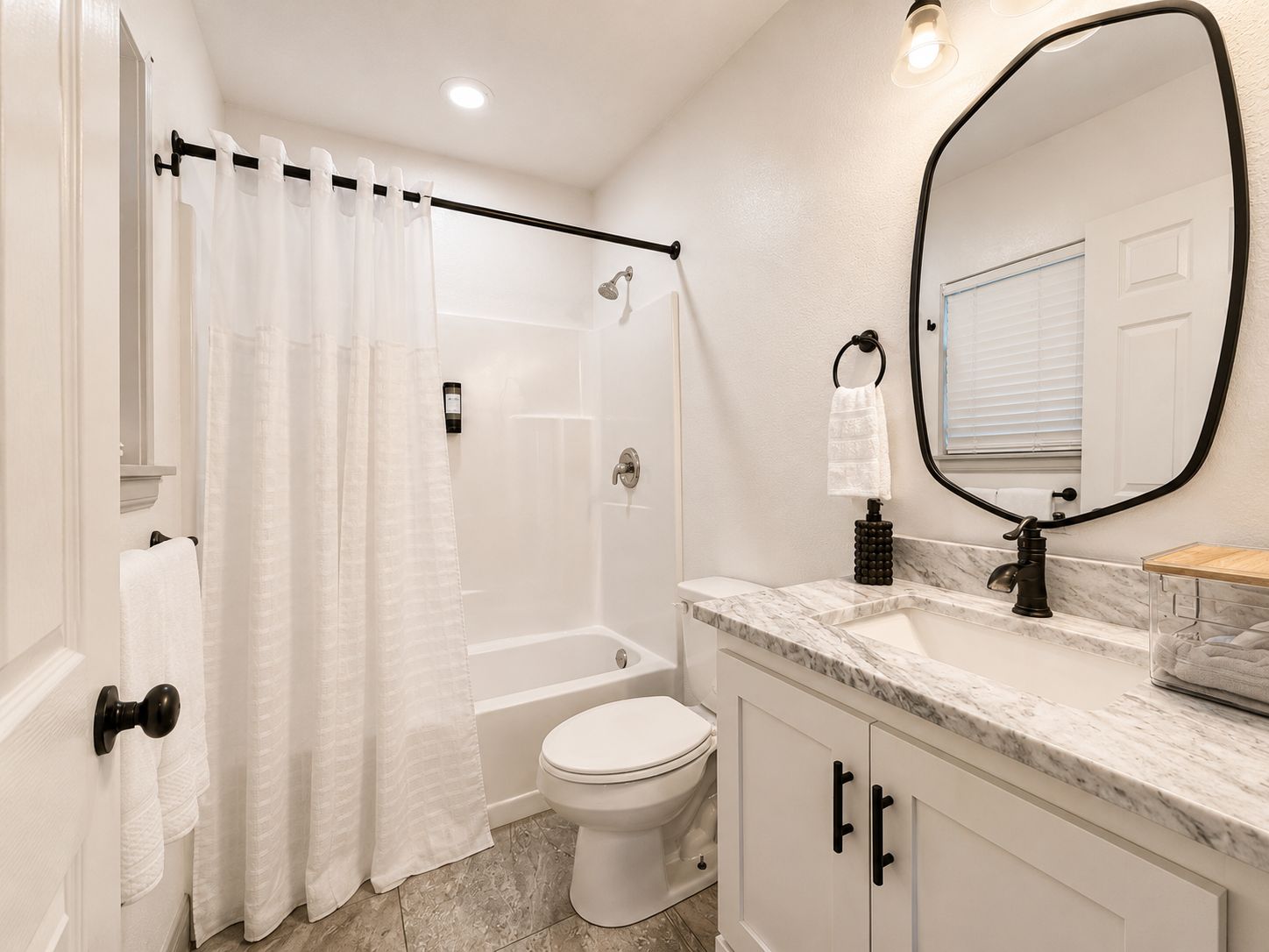 Un bagno con doccia, WC e un mobile lavabo con specchio.