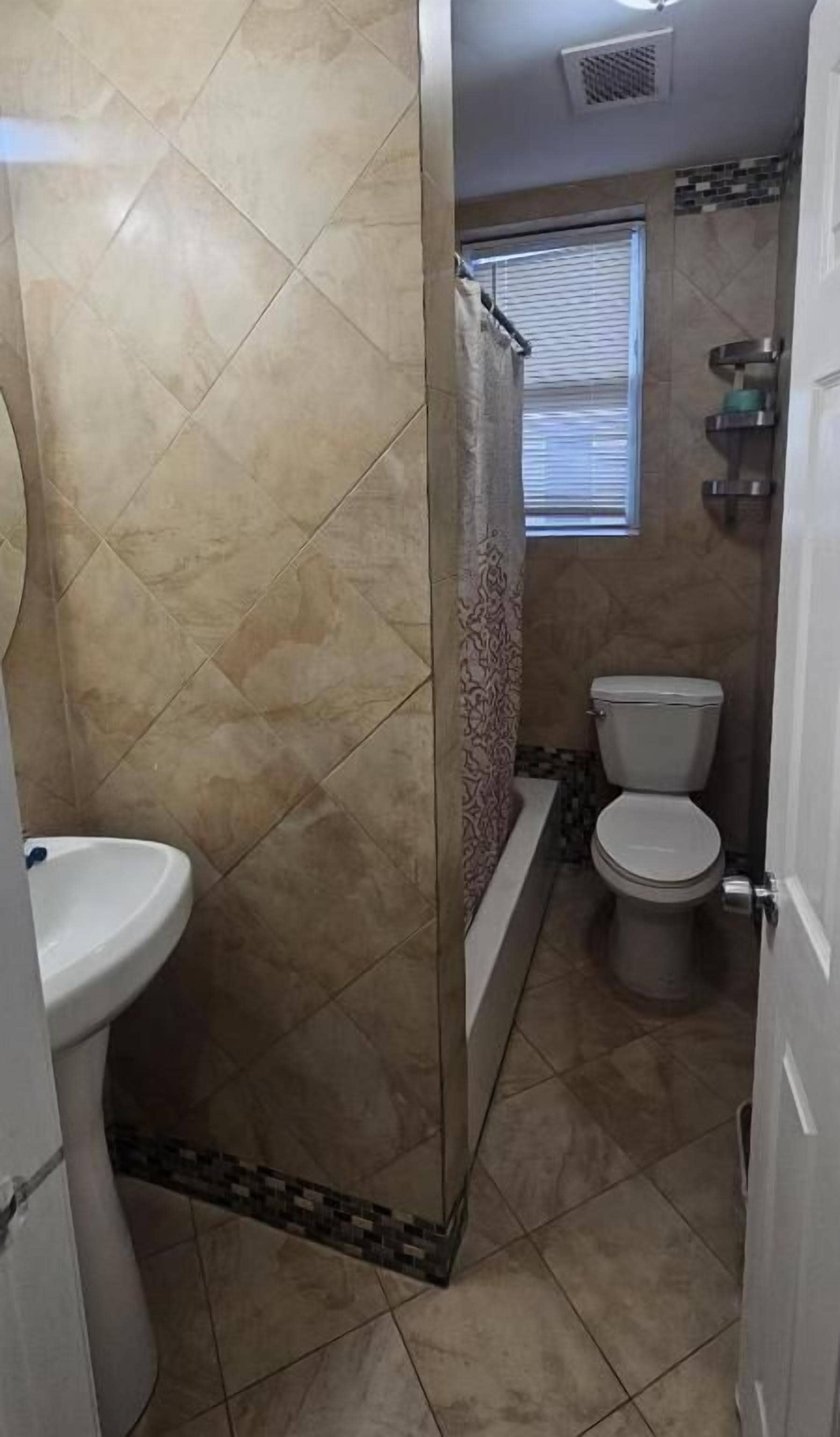 Un baño con ducha, inodoro y lavabo.