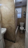 Un baño con ducha, inodoro y lavabo.