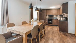 Una cocina moderna con armarios de madera oscura, horno empotrado y microondas.