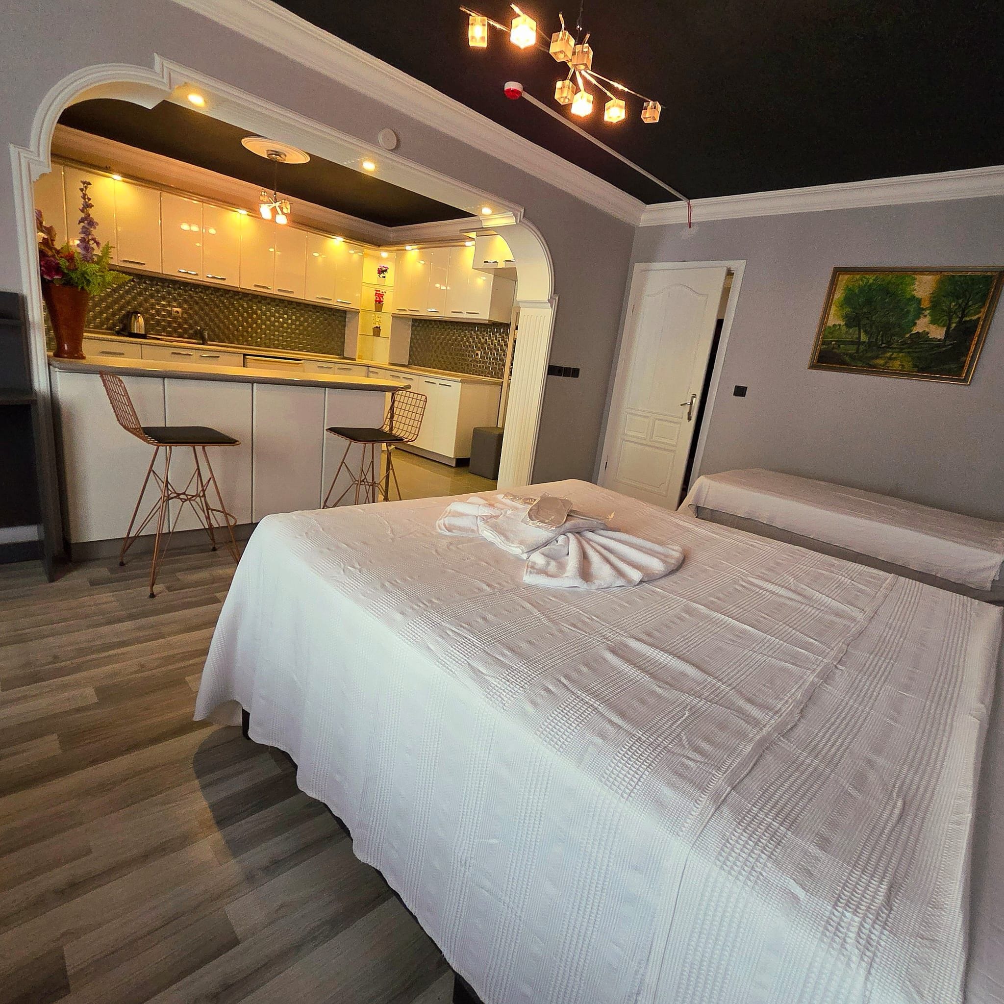 Un dormitorio con una cama grande, una kitchenette y un comedor.