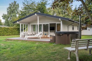 Un espace extérieur abrité comprenant une table de billard, des chaises longues et un jacuzzi.