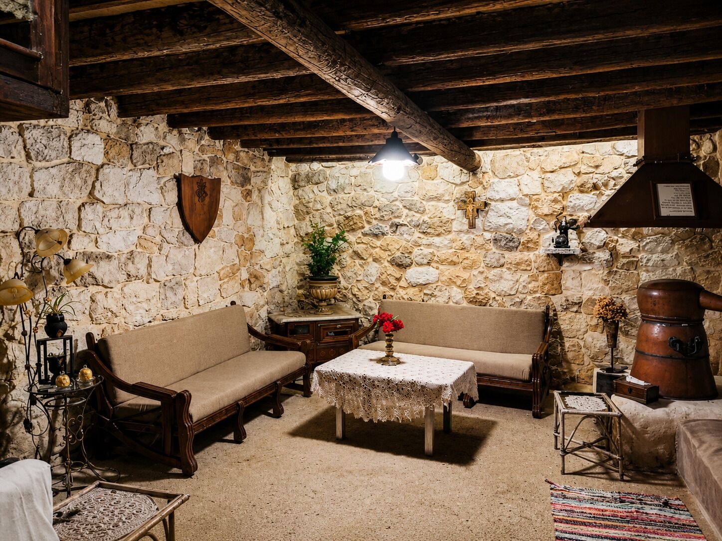 A rustic room with stone walls, wooden furniture, and a traditional fireplace.