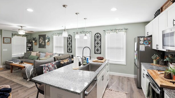 A modern kitchen with a central island, built-in appliances, and a dining area with a sofa and coffee table. - Mountain View Retreat with Hot Tub,Pet-Friendly,Near Asheville & Biltmore (Arden)