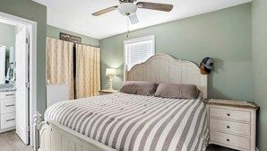 A bedroom with a bed, nightstands, a ceiling fan, a window with blinds, and a door. - Mountain View Retreat with Hot Tub,Pet-Friendly,Near Asheville & Biltmore (Arden)