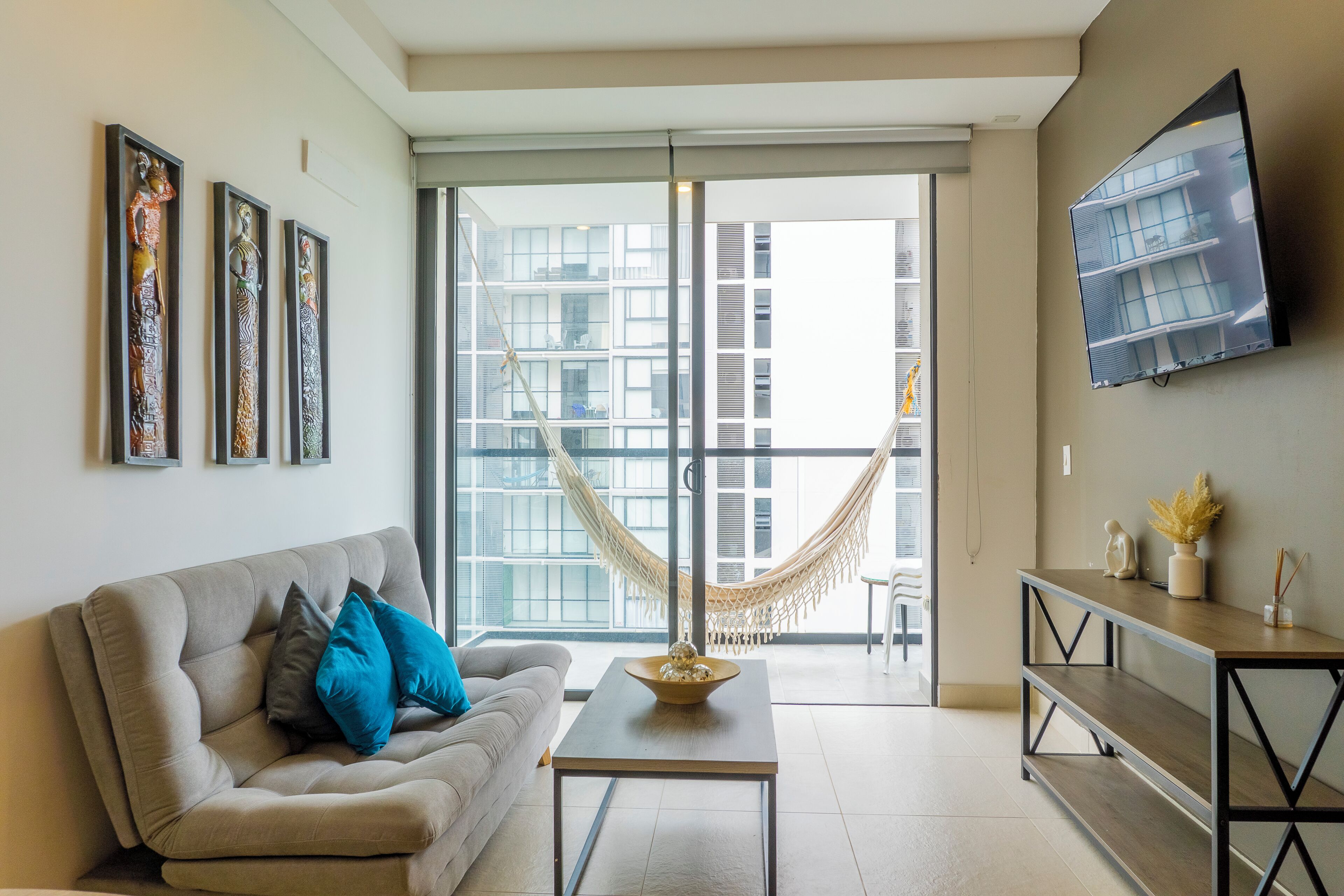 A modern living room with a sofa, coffee table, and a hammock.