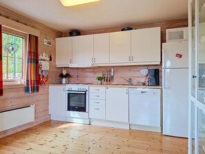 A compact kitchen with white cabinets, a Bosch oven, a dishwasher, and a refrigerator. - Bjørnbu by Interhome (Eikerapen)